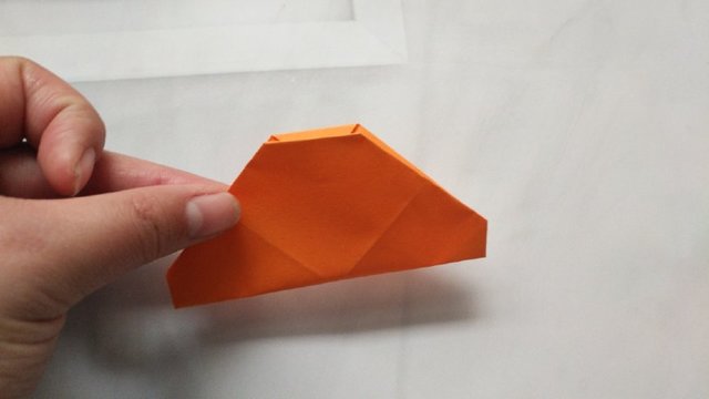 步骤10：然后把纸张对折，对折出一个饺子类似三角的样子。