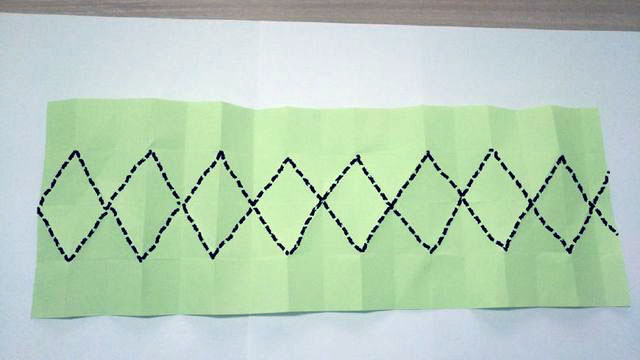 步骤4：接着上面的，这一步我们把纸张折出这样一个一个的菱形，折的时候可以把2个格子对折，然后一起折，这样可以一下折4道折痕。如果不明白的话，就按照你们自己的想法来折。