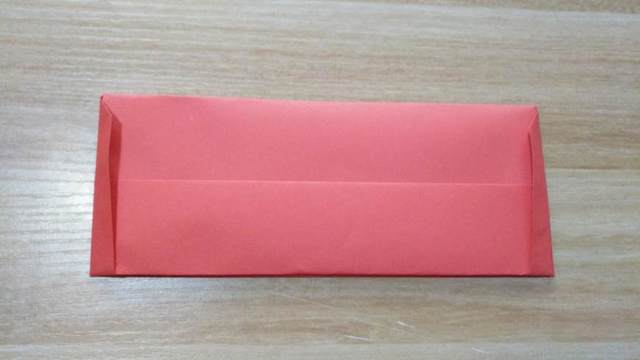 步骤3：这里是一张大图，到这里一个简单实用大容量的钱包就做好了，再说一遍，怕你们忘记了，这里底下钱包的左右2个角注意是卡在里面的，就是前面的纸的角包在后面的纸折的角里，然后把折痕对齐，钱包四周纸张整理一下，最后把钱包左右对折一下。到这里一个完整的钱包折叠方法就介绍完了。