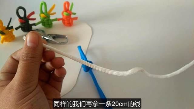 步骤12：再拿一条20cm的白色线，这个线是用来做头巾的，颜色还是选自己喜欢的就好