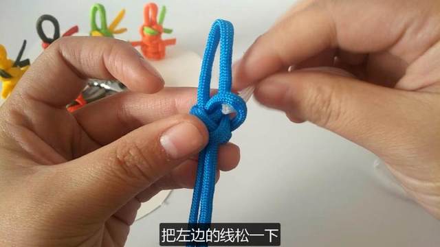 步骤13：先把右边顶端的孔松一下，白色的绳子从孔穿过来