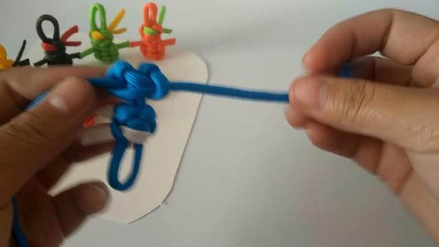 步骤20：接着再打一个双向平结，这是双向平结的第一步，右边的线从底下绕到左边，左边的线从上面绕到右边，注意看下图片就清楚了