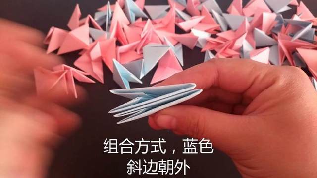 步骤11：把折好的蓝色和粉丝的小三角线部件，2个蓝色的在外面，粉色的在里面，插在一起组合，注意蓝色三角插的斜边朝外