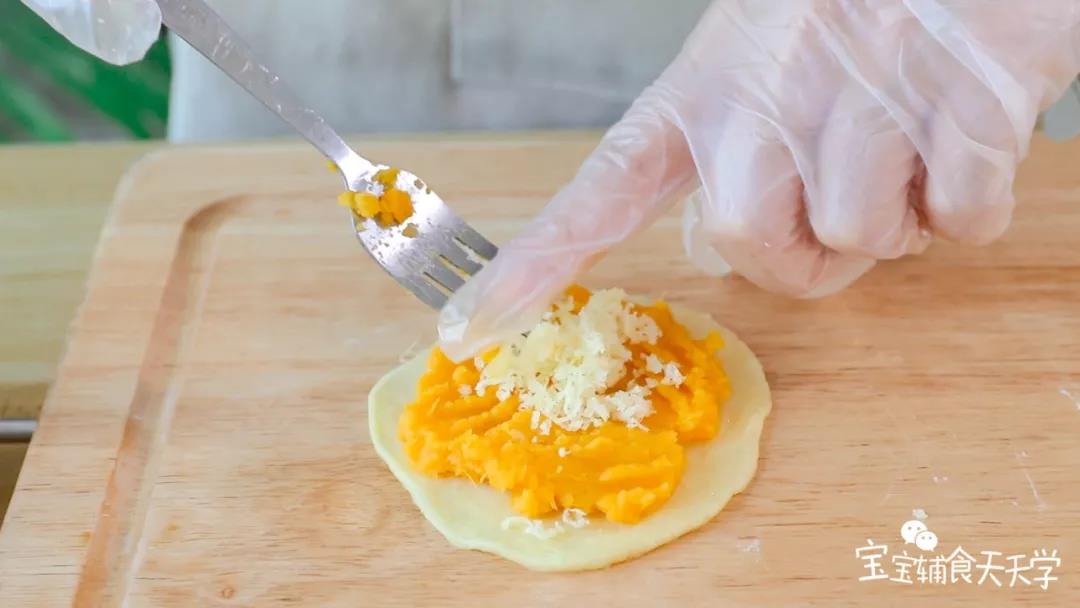 第9步：取一面团压扁，放上红薯泥压扁，铺上些奶酪碎在中心