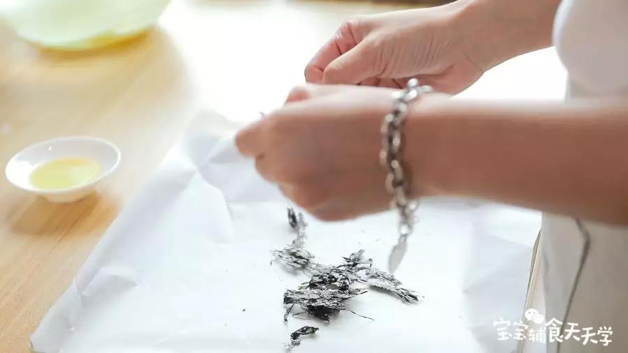 第10步：头水紫菜撕开铺在烤盘上，撒上一点点盐