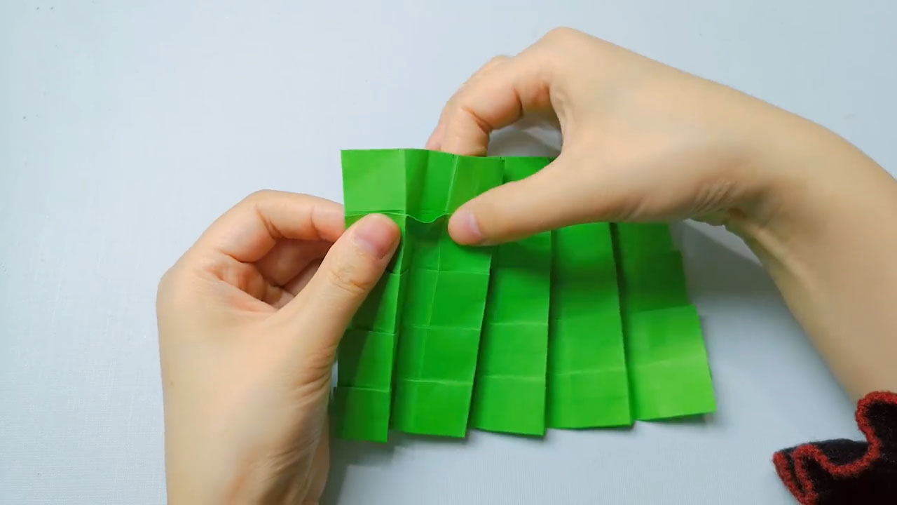 步骤5：向内折叠的地方拉出来，折出小三角。