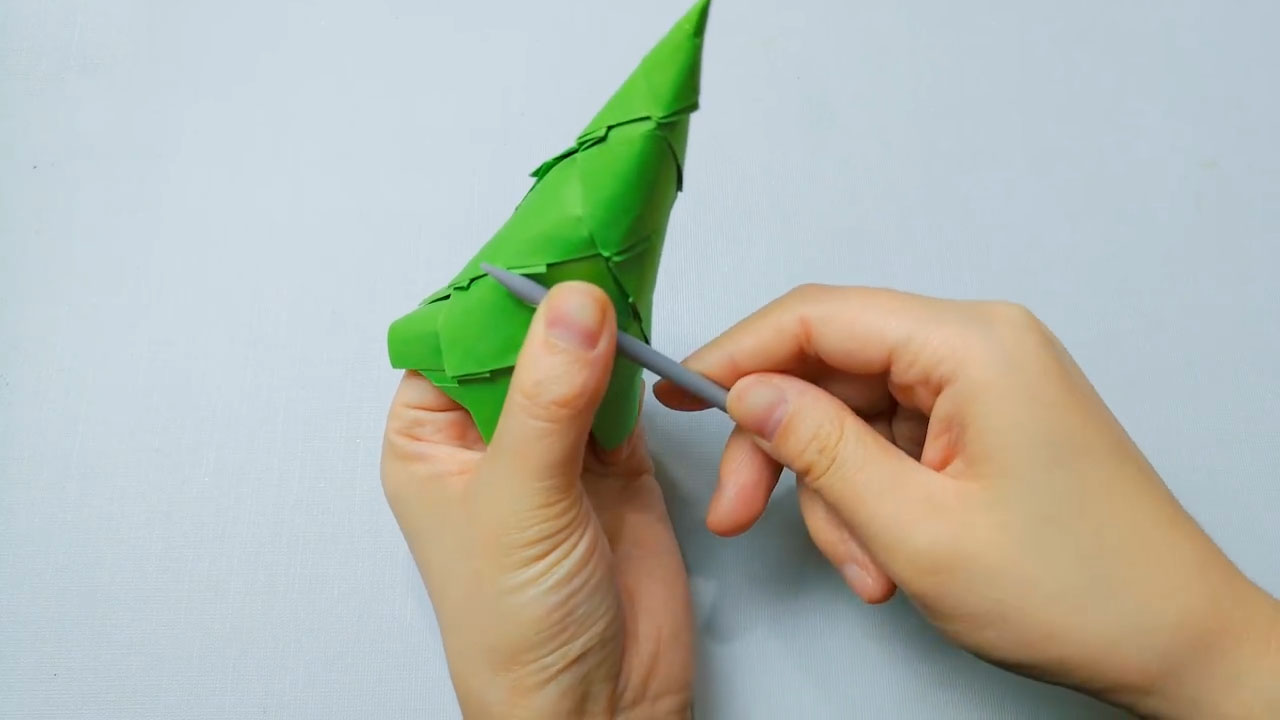 步骤16：用笔把圣诞树的小角卷起来。