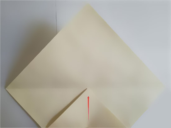 步骤2：将正方形纸的一角按照折痕对折一半。