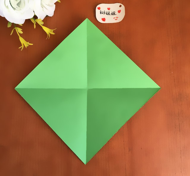 步骤1：将正方形的2条对角线折出十字折痕，如图所示。