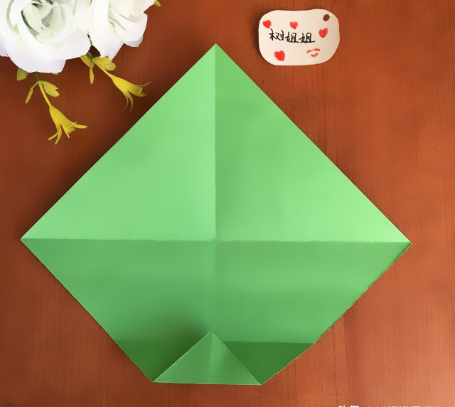 步骤3：将底部直角向图2折痕与纵向中间线形成的交叉点平行对折，如图所示。