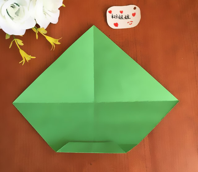 步骤4：将图3的底边平行与图2形成的折痕平行对折，形成了一个等腰梯形，如图所示。