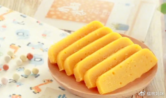 将蒸好的蛋黄南瓜糕脱模取出，将硅油纸撕掉，把糕体切成条状，蛋黄南瓜条就做好了。