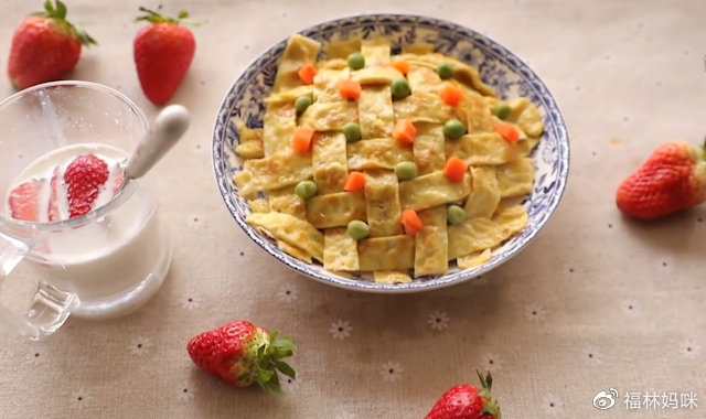 第7步：在鸡蛋条交叉的地方点缀一些青豆和胡萝卜丁，看上去更加美观。