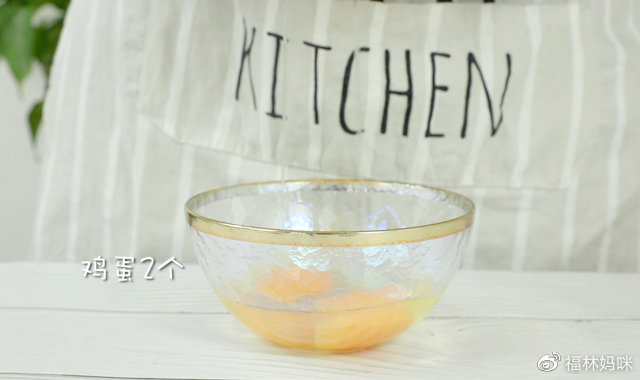 碗中磕入两个鸡蛋，均匀的打散。
