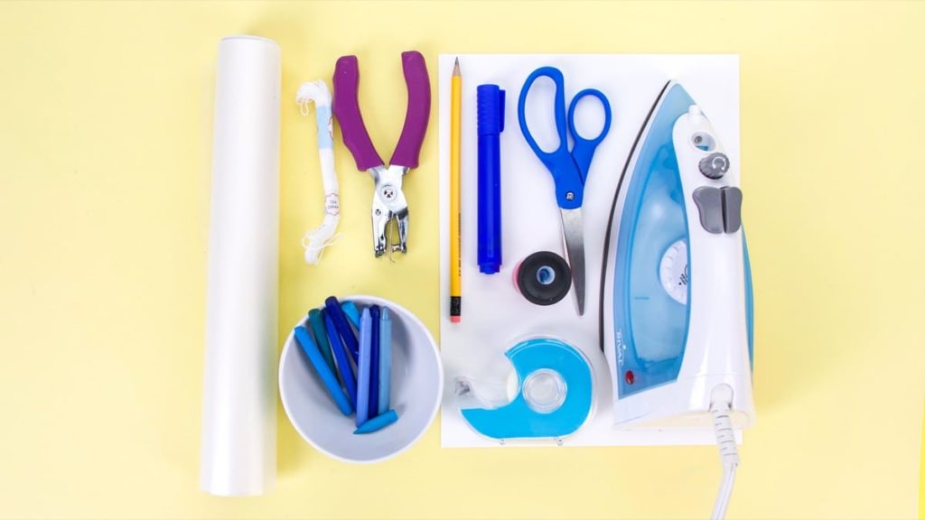 步骤1：需要准备的工具：2张白色卡片纸、蜡笔、蜡纸、熨斗、打孔机、白线或蓝线、卷笔刀、碗、蓝色记号笔、固体胶胶、剪刀