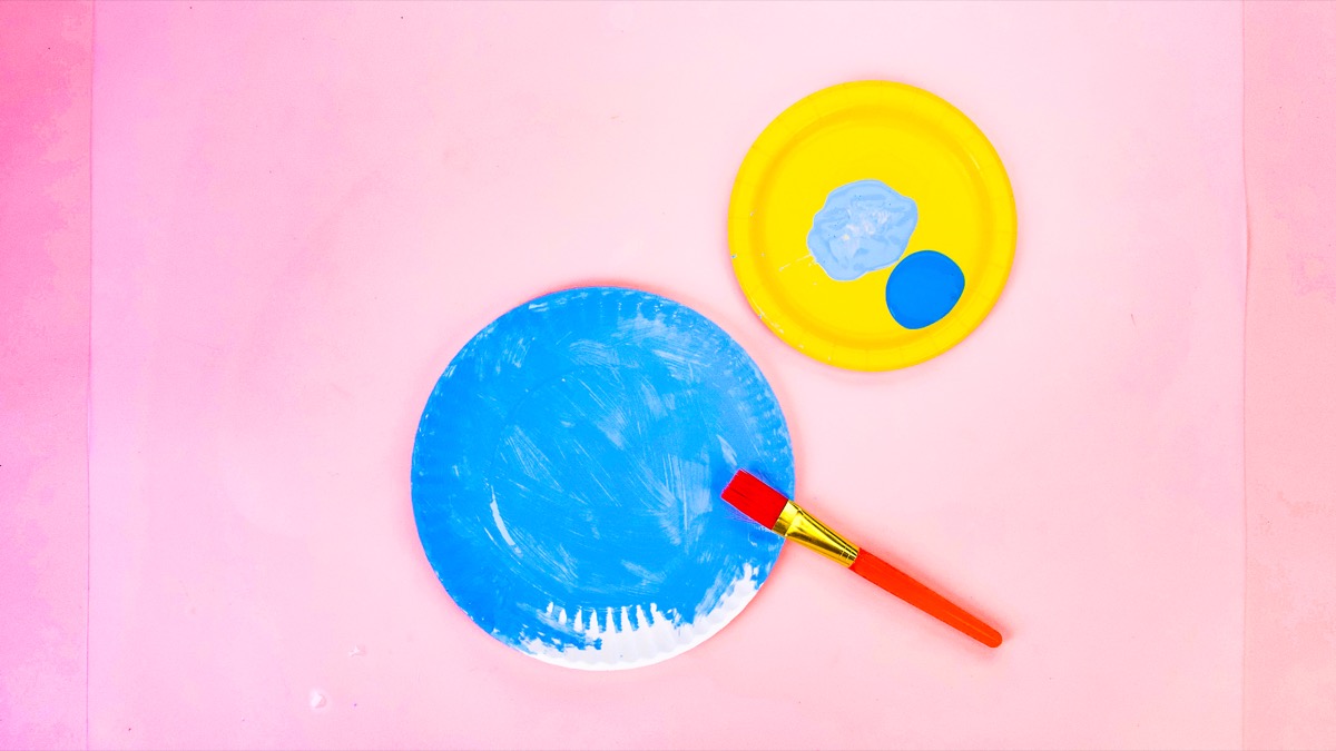 步骤2：首先，将您的纸盘中的大部分涂成浅蓝色，使天空呈蓝色。