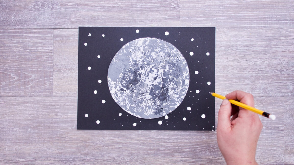 步骤4：接着我们制作星星，我们用铅笔来画星星!将铅笔的橡皮擦末端浸入白色油漆中以刻印大星星，然后使用铅笔的书写末端制作较小的星星。