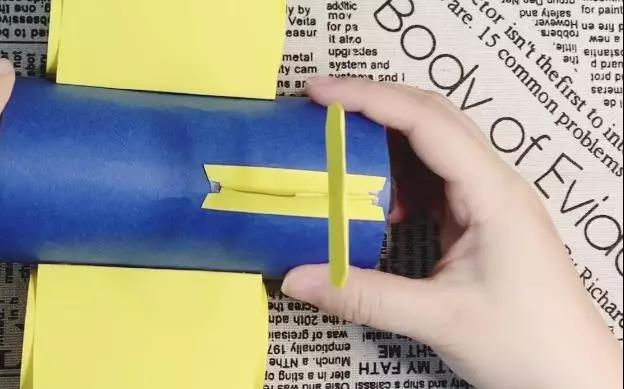 步骤9：底部两边向外折，用双面胶粘贴在矿泉水瓶身尾部中间。