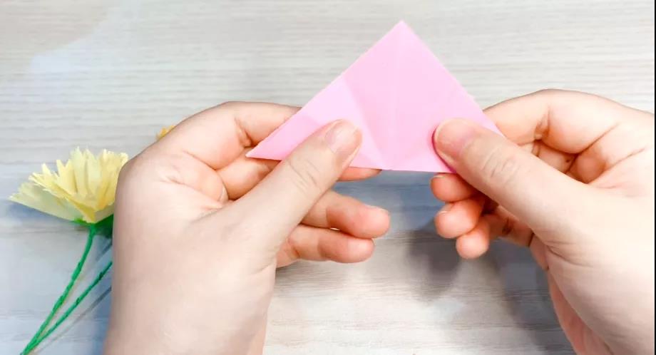 步骤1：正方形卡纸对折成三角形，然后再对折一次。