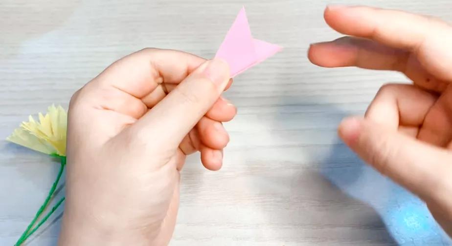 步骤2：正反两面折成三等分后将顶部的两个尖角剪去。