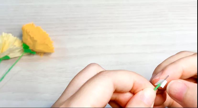 步骤6：细铁丝缠上绿色的卡纸（如果没有细铁丝可以直接用绿卡纸卷成吸管状），顶部贴上双面胶。