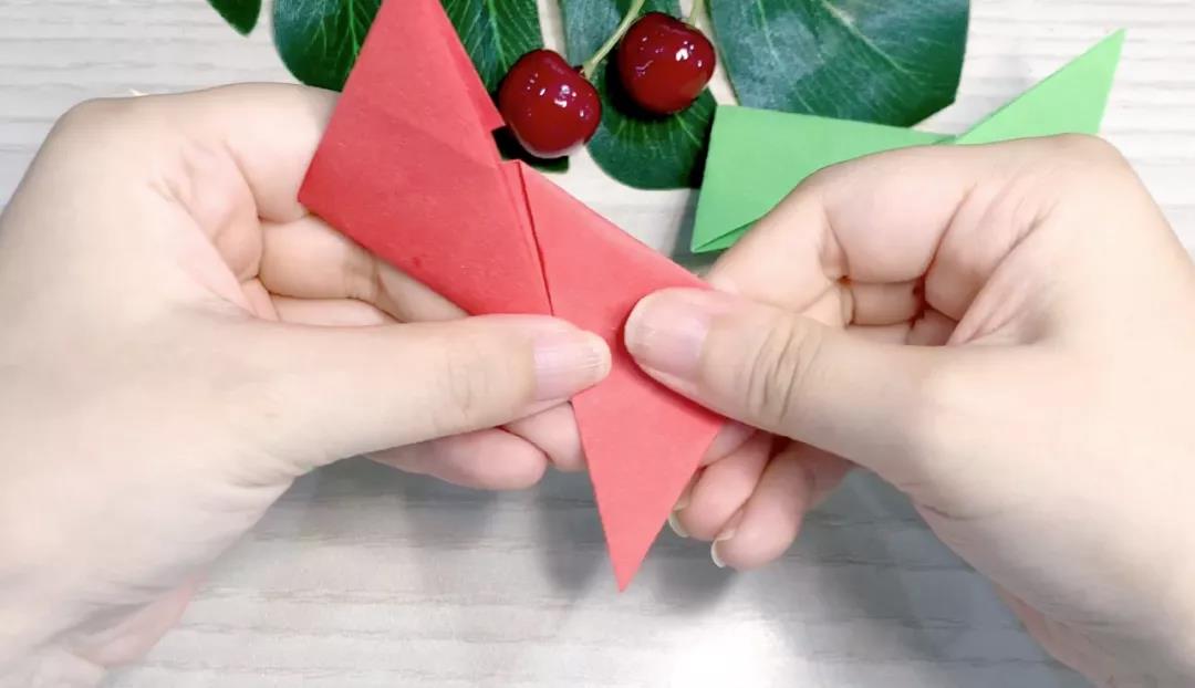 步骤5：红色卡纸则按绿色相反的方向折，左下右上。