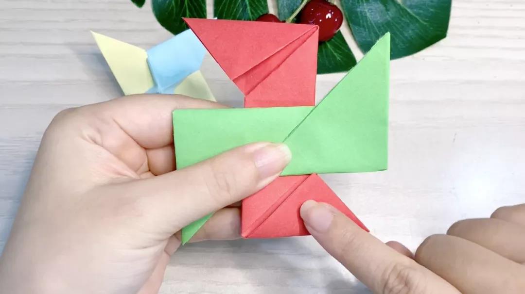 步骤6：红色卡纸中间有开口的朝后，绿色卡纸中间有开口的朝前，两个垂直交叠在一起。