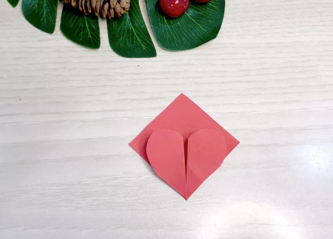 步骤22：将两枚心形向正方形折，并反向对方折，形成一个敞开的心形。