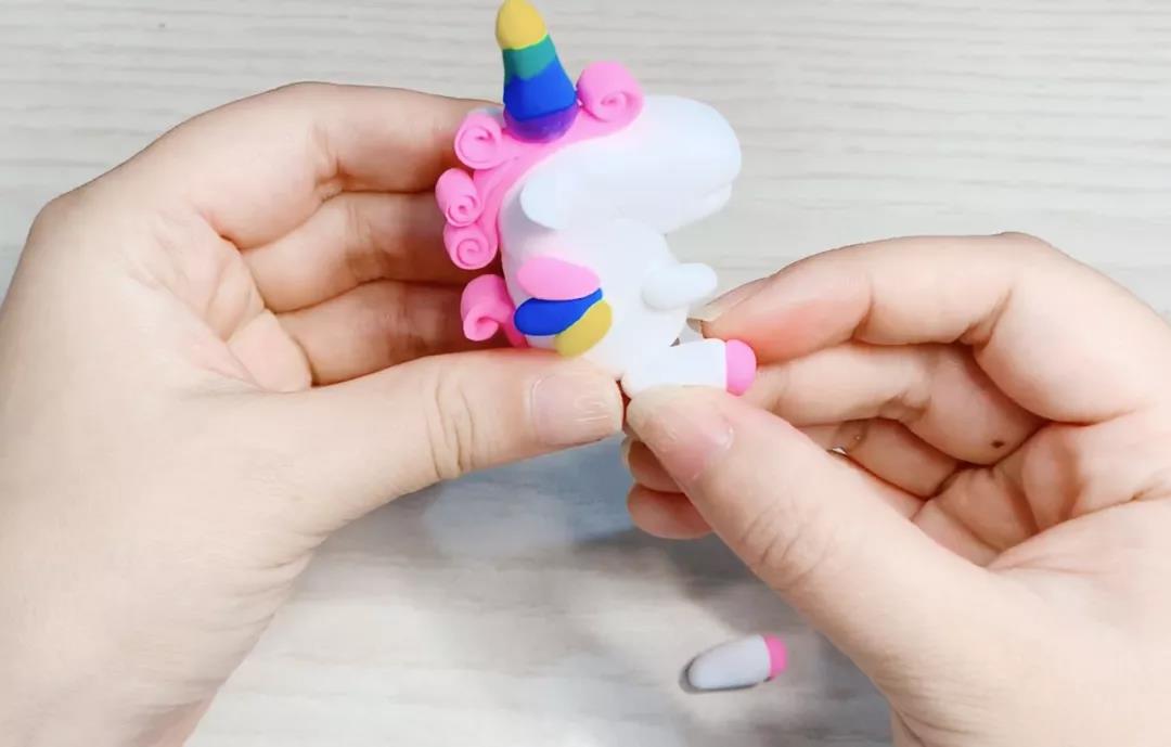 步骤14：用同样的方法做两个大一点的圆柱，底部贴上一点粉色的黏土，粘在底部做独角兽的后肢。