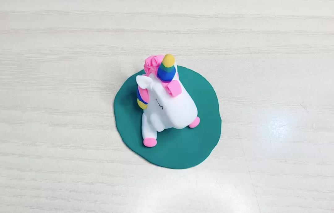 步骤16：用绿色黏土给独角兽做个“坐垫”。