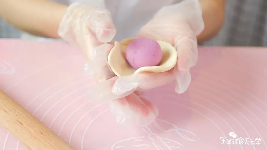 把白色面片包住紫色面团，跟包包子一样，依次慢慢收口，捏紧