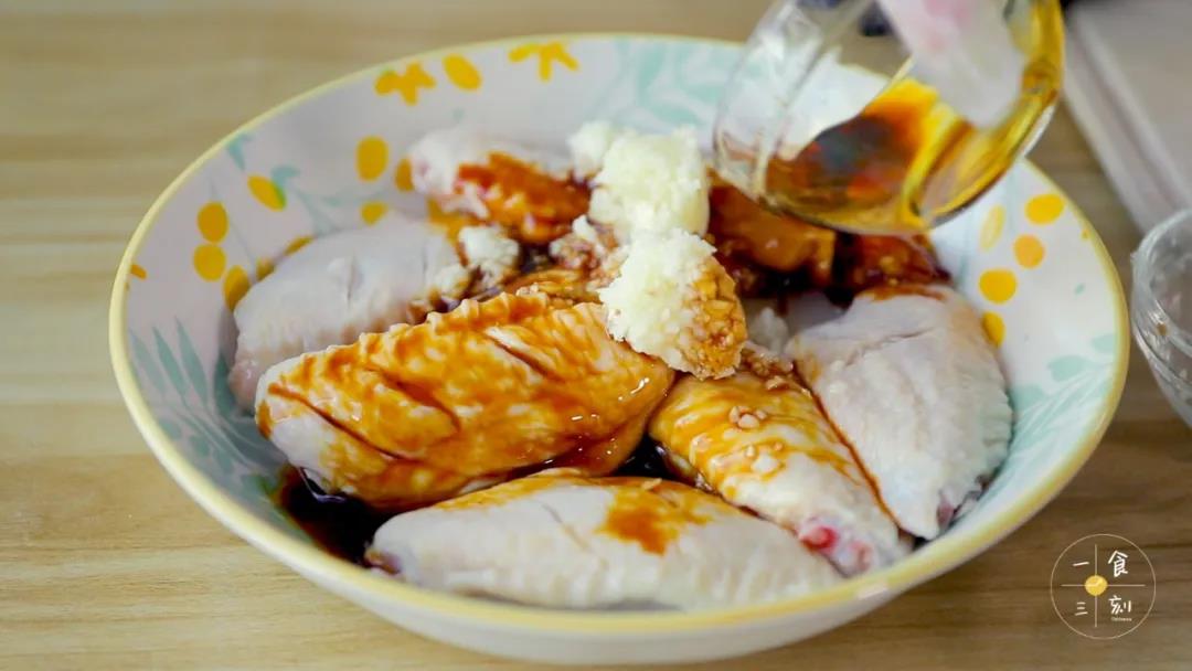 把黑胡椒、蚝油、生抽、料酒、鸡精、蒜末和少量柠檬汁倒入鸡翅中，抓匀