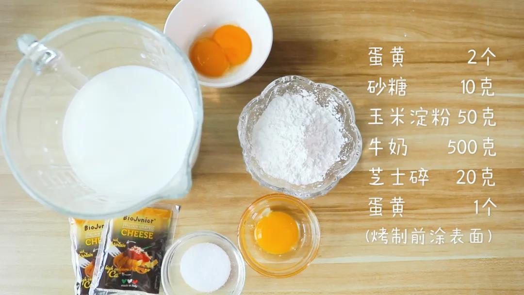 食材准备：蛋黄2个，砂糖10克，玉米淀粉50克，牛奶500克，芝士碎20克，另蛋黄1个(烤制前涂表面)