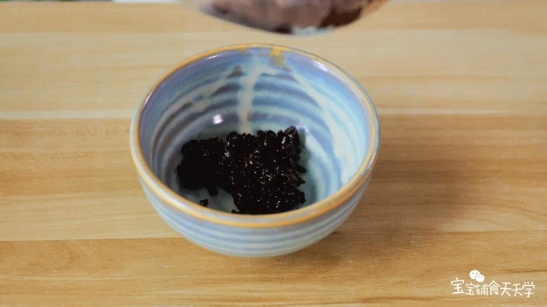 加了糖的熟黑米勺起适量放入碗里