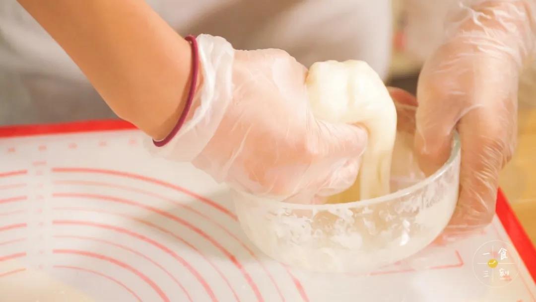 蒸好后取出放至温热后，戴上手套把蒸好的糯米团揉软