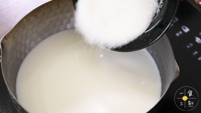 现在来制作布丁液，牛奶里加入细砂糖，慢火加热搅拌融化