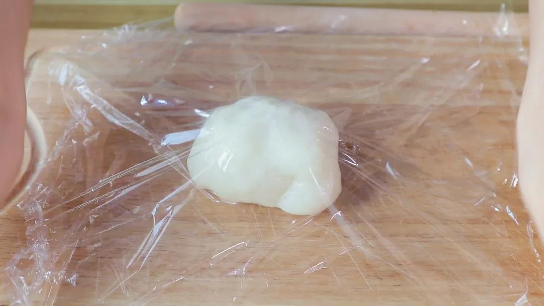 铺开一张保鲜膜，放上糯米团，再盖上一张保鲜膜