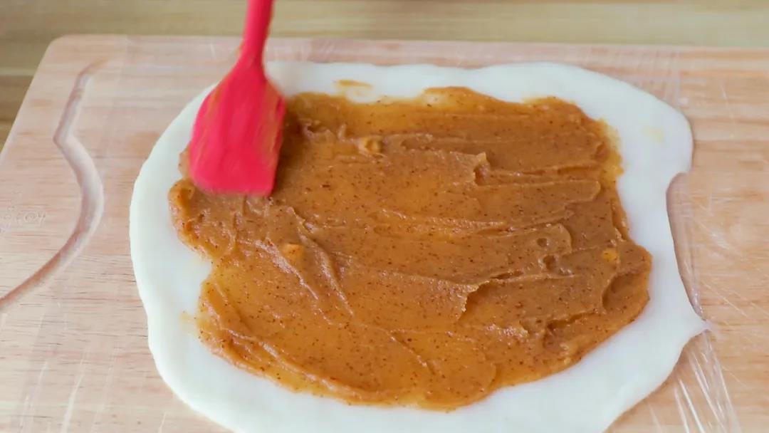 揭开保鲜膜，在糯米皮上铺上枣泥