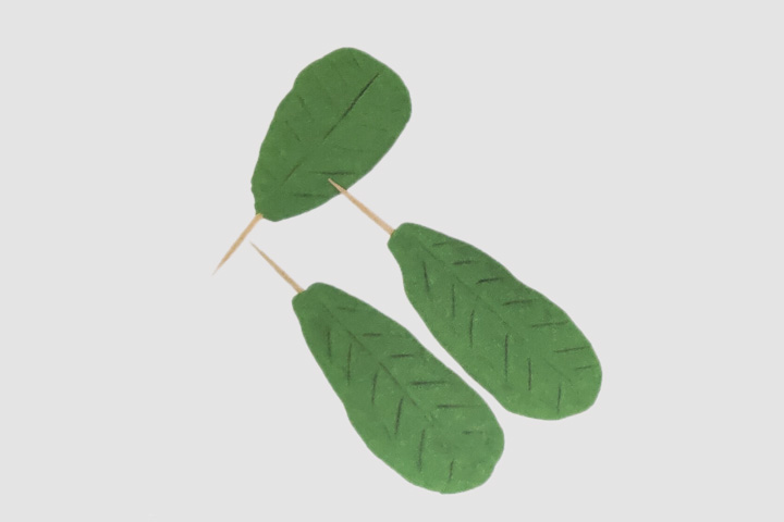 步骤3：捏出绿色萝卜叶，并划出叶脉插入牙签。