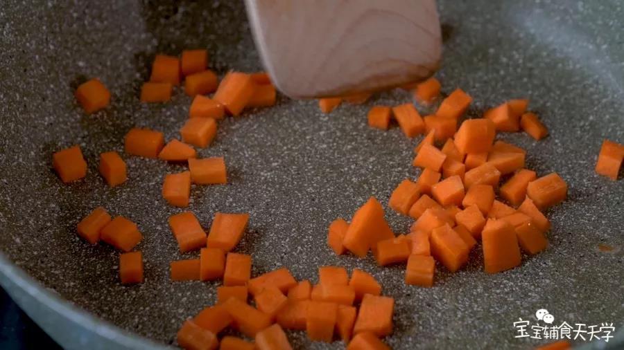 第3步：锅里倒油，小火加热，倒入胡萝卜粒翻炒炒软