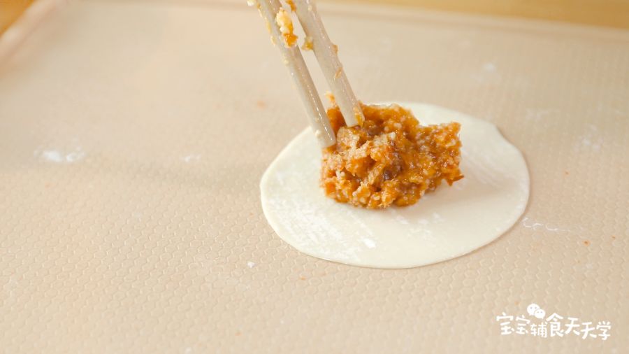 取一张饺子皮，中间放上馅料