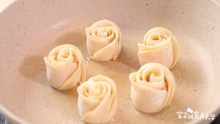 倒油热锅，放入玫瑰花饺子煎香