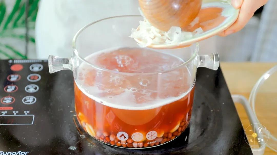 待莲子和红豆都煮绵软后，倒入提前浸泡好的银耳和百合