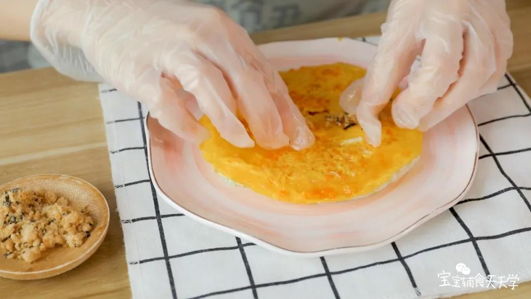 第11步：把蛋白饼放下面，叠一张蛋黄饼，中间铺上宝宝肉松或鳕鱼松