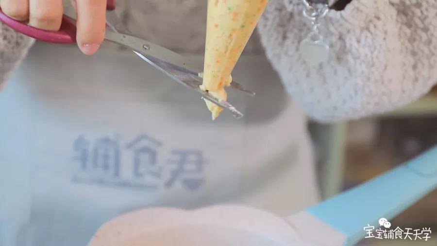 裱花袋剪开一个口，边挤出肉泥边用剪刀剪断