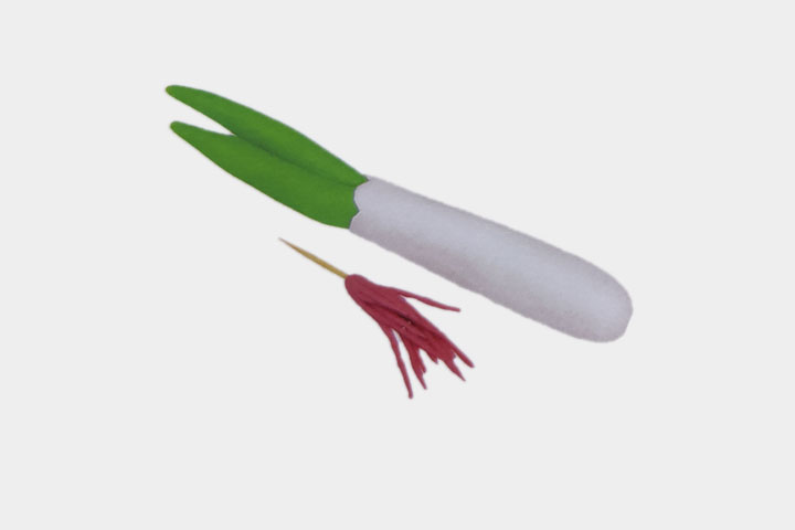 步骤3：把葱叶插到葱白人凹处，搓出粉色根须，并插上牙签。