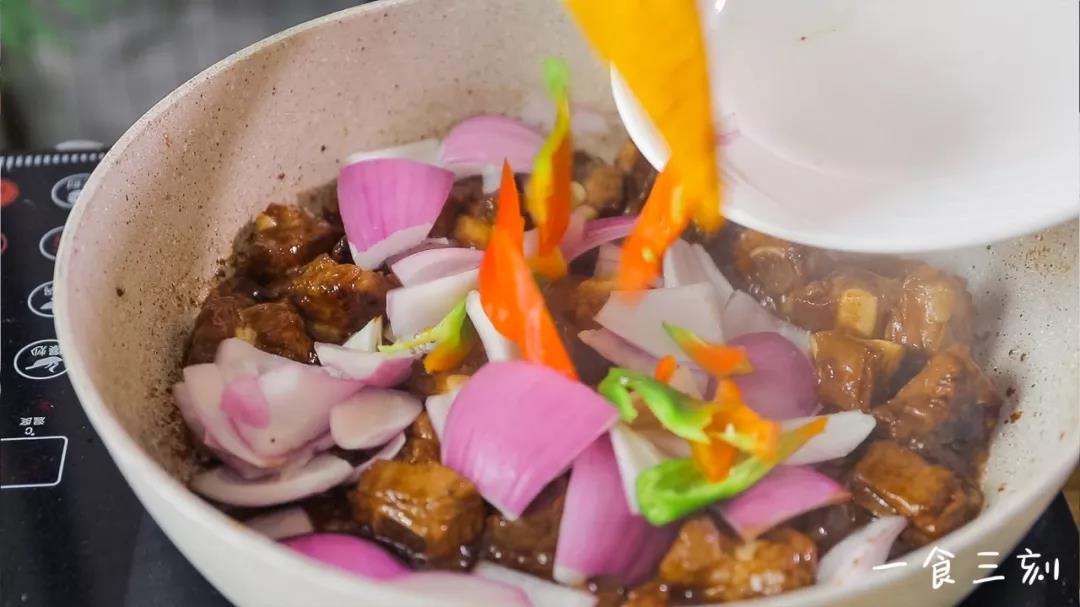 放入洋葱、青椒，加入适量清水，加盖焖至收汁