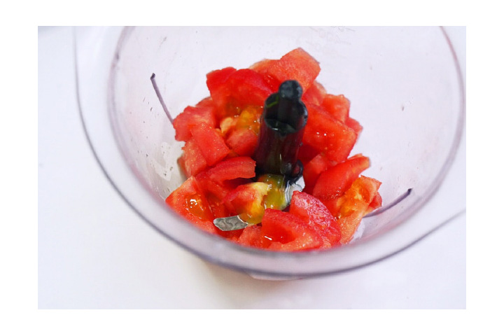 将番茄顶部划十字，放碗里倒入开水，烫一番茄去皮后去掉根部，切成丁，放入料理机中。下方便退皮。