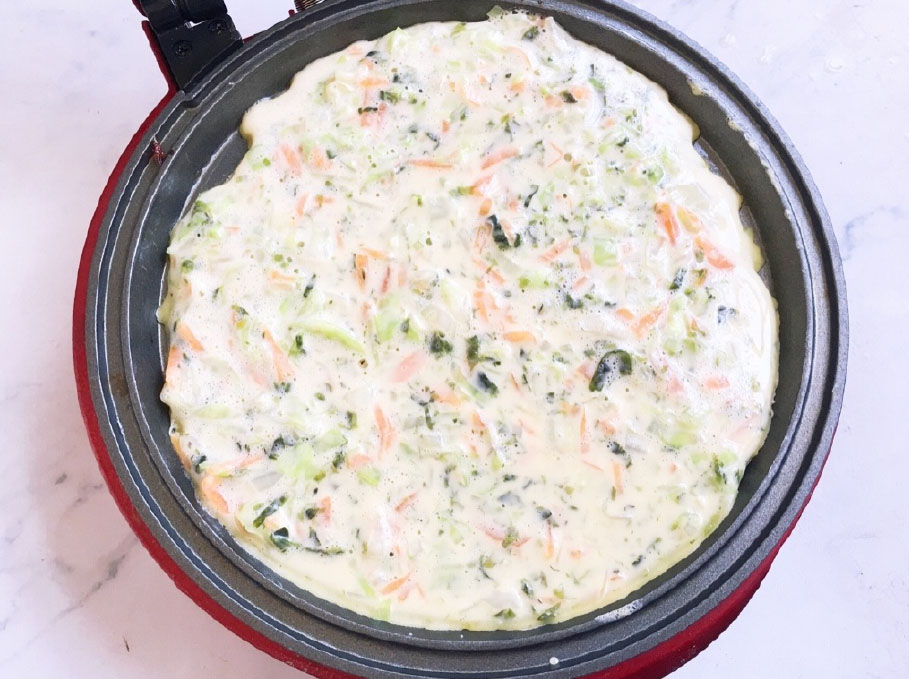 小红锅预热后刷一点点油，将面糊倒入锅中，用铲子轻轻摊开。