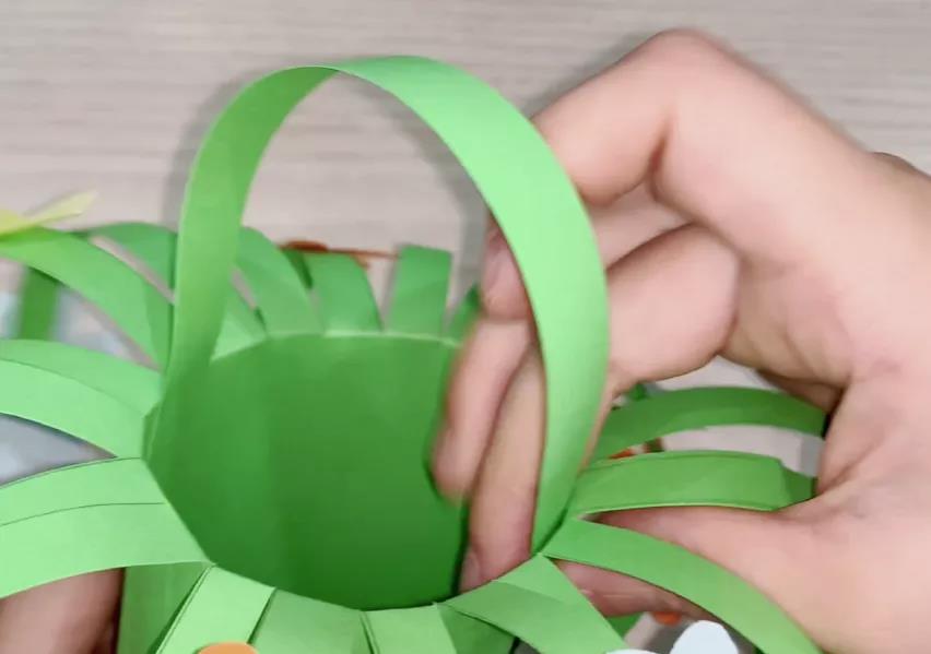 步骤11：选一根绿色长条头尾贴上双面胶，贴在圆桶内部当做提手。